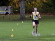 Columbia River senior Jacob McManus leads Ridgefield senior Davis Sullivan during the Class 2A boys race at the District 4 Cross Country Championships at Lewis River Golf Course on Thursday, Oct. 31, 2024.