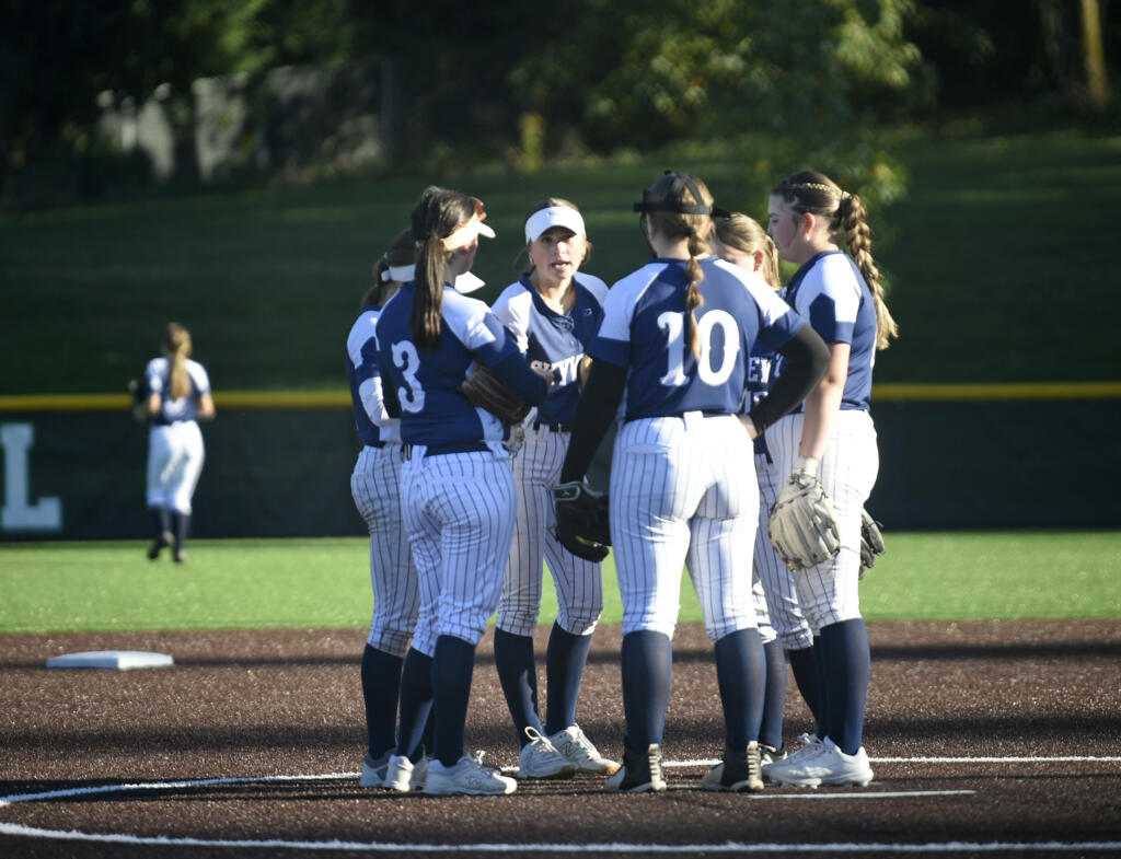 Skyview's Taylor Lies, center, talks to teammates in the pitcher's circle between innings of the Class 4A district slowpitch softball championship against Union on Wednesday, Oct. 16, 2024, at Evergreen High School.