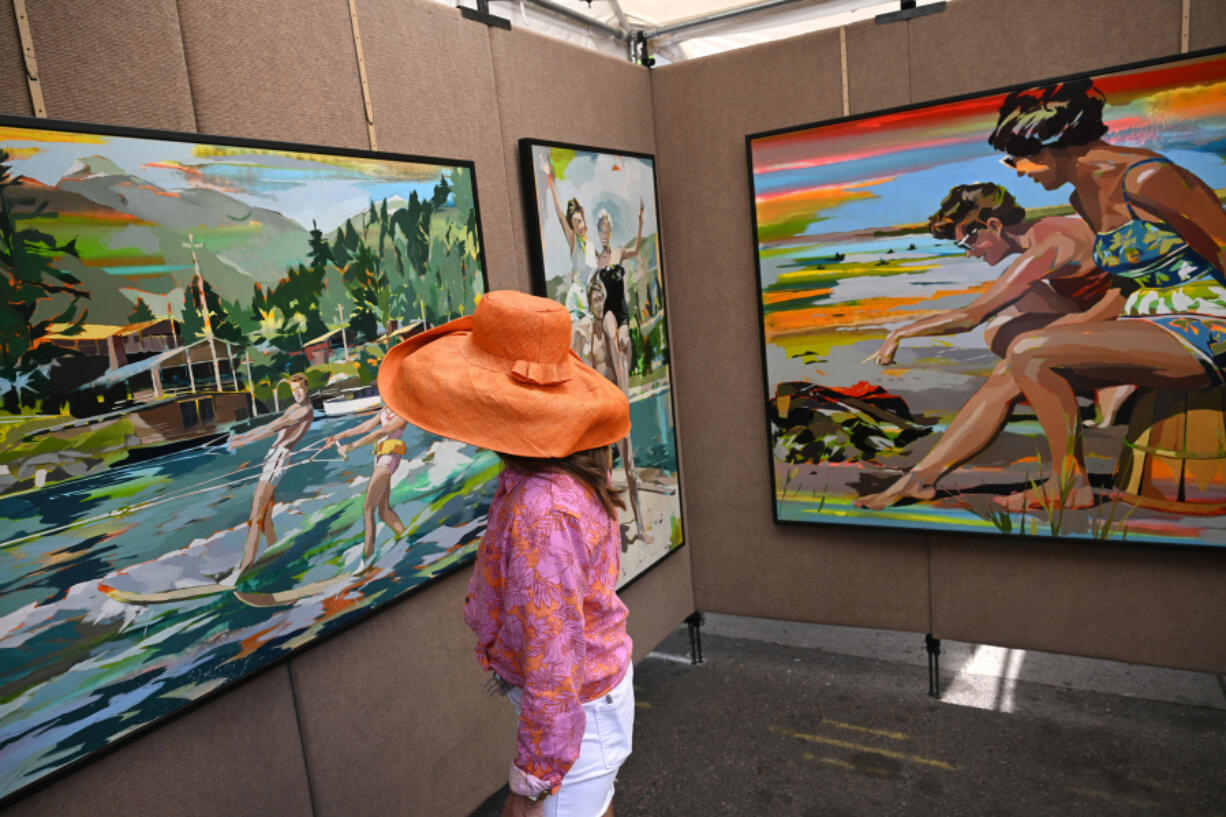 Rebecca Burckhardt checks out the artwork of Signe &amp; Genna Grushovenko on display at the Cherry Creek Arts Festival in Denver on July 7, 2024. (Helen H.