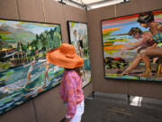 Rebecca Burckhardt checks out the artwork of Signe &amp; Genna Grushovenko on display at the Cherry Creek Arts Festival in Denver on July 7, 2024. (Helen H.