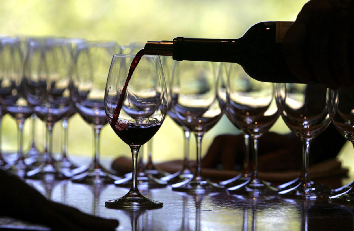 A worker at St. Supery winery pours a glass of wine for a tasting Sept. 20, 2006, in Rutherford, Calif.