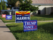 Competing political signs depict differing views in the same household on the lawn in front of a home in this suburban neighborhood on Oct. 1, 2024 in Mesa, Arizona.