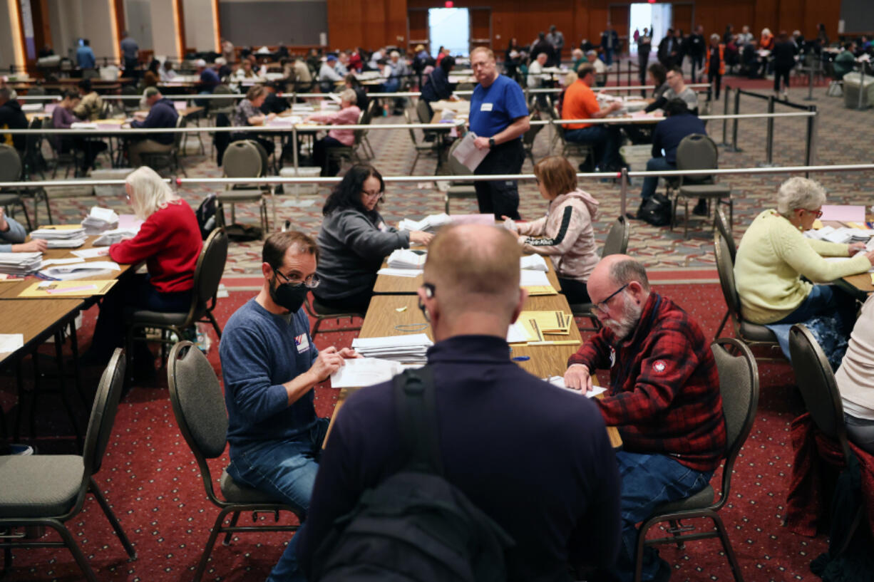 An election observer watches as workers count mail-in and in-person absentee ballots at the Wisconsin Center on Nov. 08, 2022, in Milwaukee, Wisconsin. After months of candidates campaigning, Americans are voting in the midterm elections to decide close races across the nation.