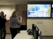 Vancouver Mayor Anne McEnerny-Ogle, right, records video on her phone Thursday as traffic engineers light up a sign directing the usage of the new part-time shoulder lane on state Highway 14 at the northbound Interstate 205 exit.