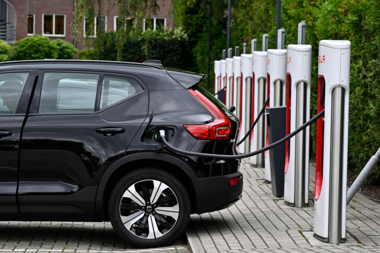 An electric car charges at a charging point reserved for Tesla cars in Breda on Sept. 19, 2023.