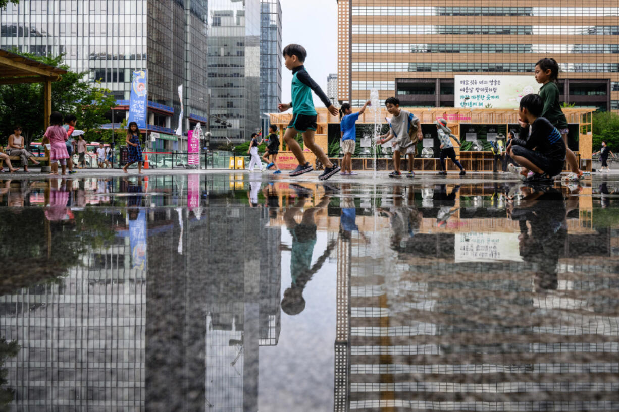 Children play among water fountains on a street in Seoul, South Korea, on Aug. 14, 2024, during a prolonged heatwave that gripped much of the country.