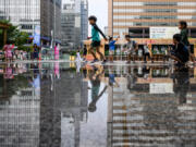 Children play among water fountains on a street in Seoul, South Korea, on Aug. 14, 2024, during a prolonged heatwave that gripped much of the country.