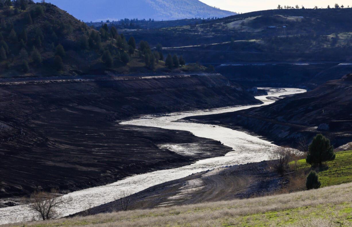 The Klamath River flows unimpeded after dams were removed, revealing reservoir-bottom lands that have been underwater for decades, on Feb. 27, 2024, in Hornbrook, California.