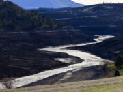 The Klamath River flows unimpeded after dams were removed, revealing reservoir-bottom lands that have been underwater for decades, on Feb. 27, 2024, in Hornbrook, California.