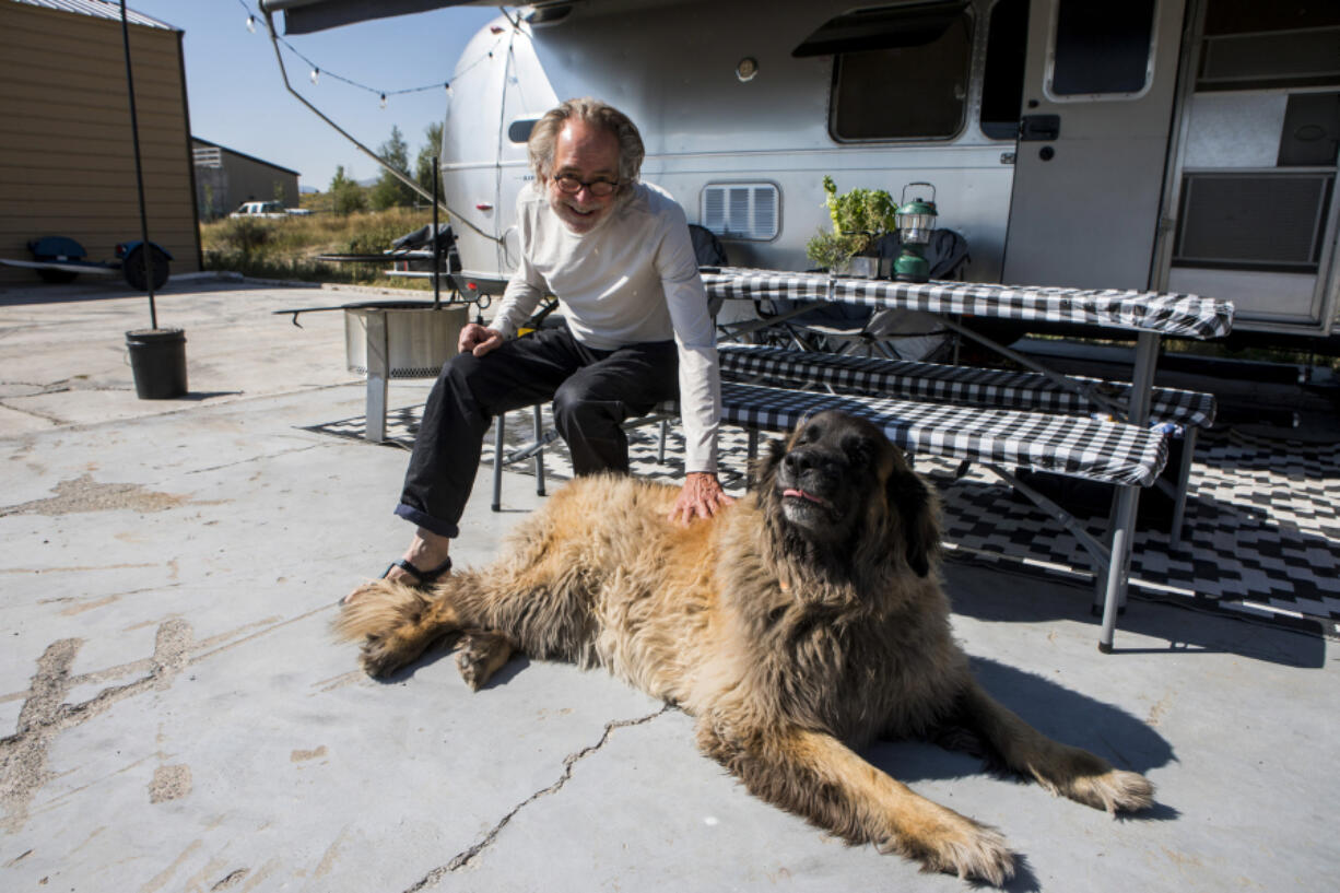 Paul Rousseau pets his neighbor&rsquo;s dog, Obie, at the fish hatchery where he volunteers in Jackson, Wyo.