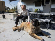 Paul Rousseau pets his neighbor&rsquo;s dog, Obie, at the fish hatchery where he volunteers in Jackson, Wyo.