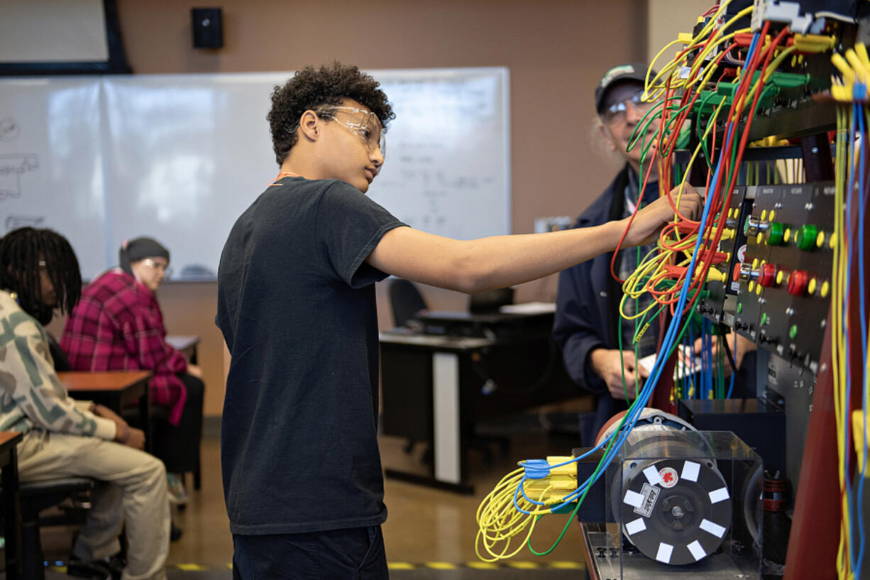 Simon Jones, 14, of iUrbanTeen, center, gets hands-on experience during a tour of the Clark College electrical and power distribution systems lab April 1. The Vancouver nonprofit has launched a new program, iSports, to introduce youth across Clark County to the world of sports management.