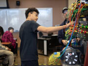 Simon Jones, 14, of iUrbanTeen, center, gets hands-on experience during a tour of the Clark College electrical and power distribution systems lab April 1. The Vancouver nonprofit has launched a new program, iSports, to introduce youth across Clark County to the world of sports management.