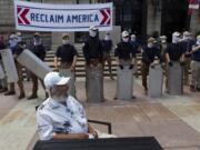 People bearing the insignia of the white supremacist group Patriot Front stand in front of the Boston Public Library in Copley Square on Saturday, July 2, 2022, in Boston.