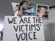 Family members of victims of Boeing plane crashes carry signs after a Senate Homeland Security Subcommittee on Investigations hearing on the Capitol Hill Tuesday, June 18, 2024, in Washington.