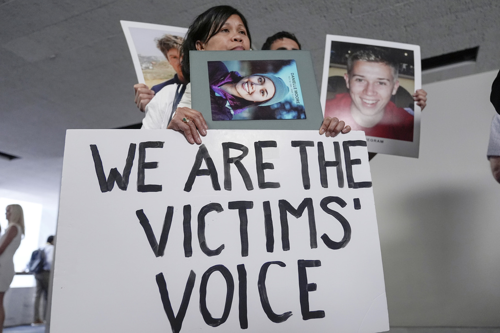 Family members of victims of Boeing plane crashes carry signs after a Senate Homeland Security Subcommittee on Investigations hearing on the Capitol Hill Tuesday, June 18, 2024, in Washington.