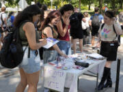 Cortney Bouse, right, explains registering to vote with University of Pittsburgh students on campus in Pittsburgh, Thursday, Sept. 12, 2024. (AP Photo/Gene J.