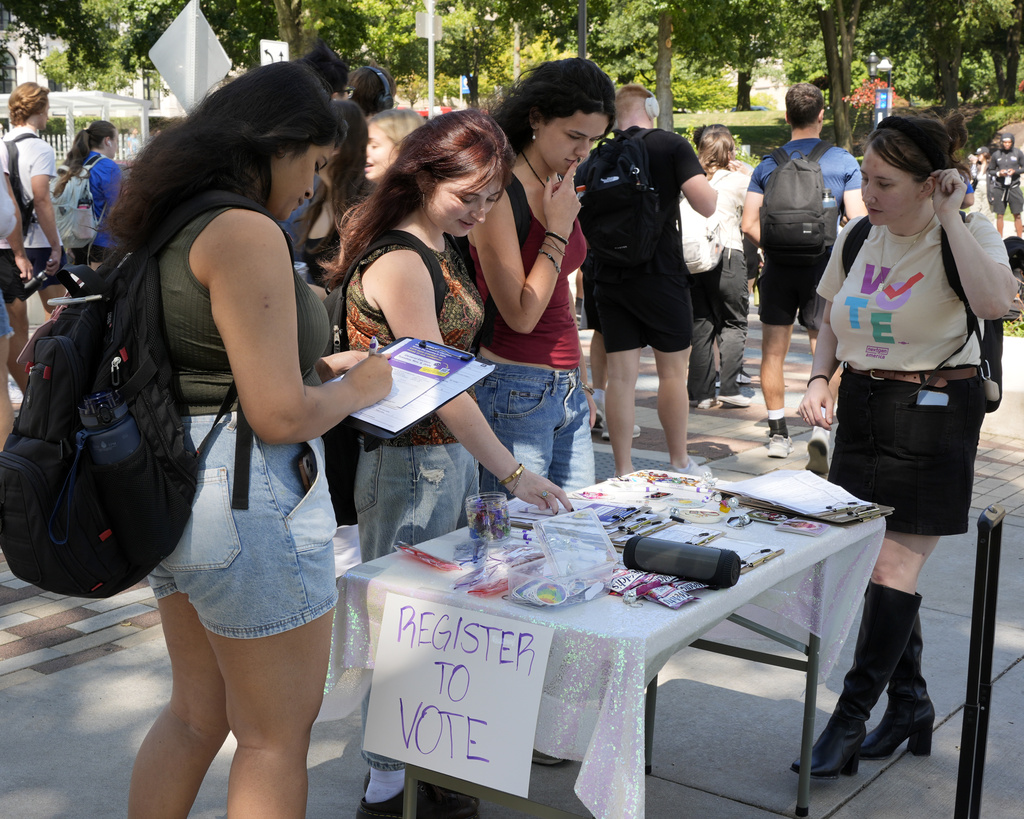 Cortney Bouse, right, explains registering to vote with University of Pittsburgh students on campus in Pittsburgh, Thursday, Sept. 12, 2024. (AP Photo/Gene J.