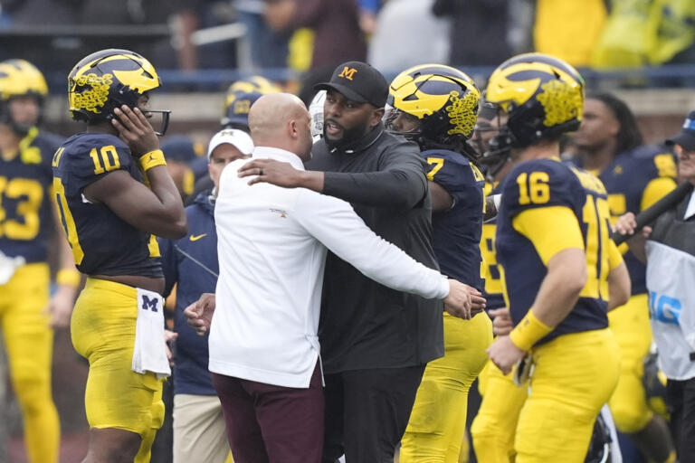 Minnesota head coach P.J. Fleck, left, hugs Michigan head coach Sherrone Moore after an NCAA college football game, Saturday, Sept. 28, 2024, in Ann Arbor, Mich.