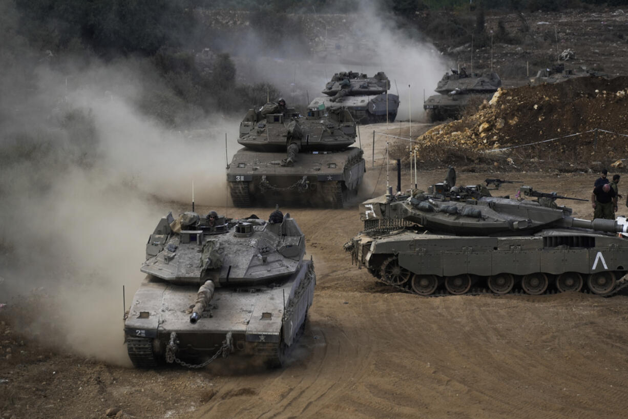 Israeli army tanks maneuver in a staging area in northern Israel near the Israel-Lebanon border, Tuesday, Oct. 1, 2024.