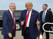 Republican presidential nominee former President Donald Trump stands with Republican National Committee chair Michael Whatley as he arrives at Fayetteville Regional Airport to attend a town hall, Friday, Oct. 4, 2024, in Fayetteville, N.C.