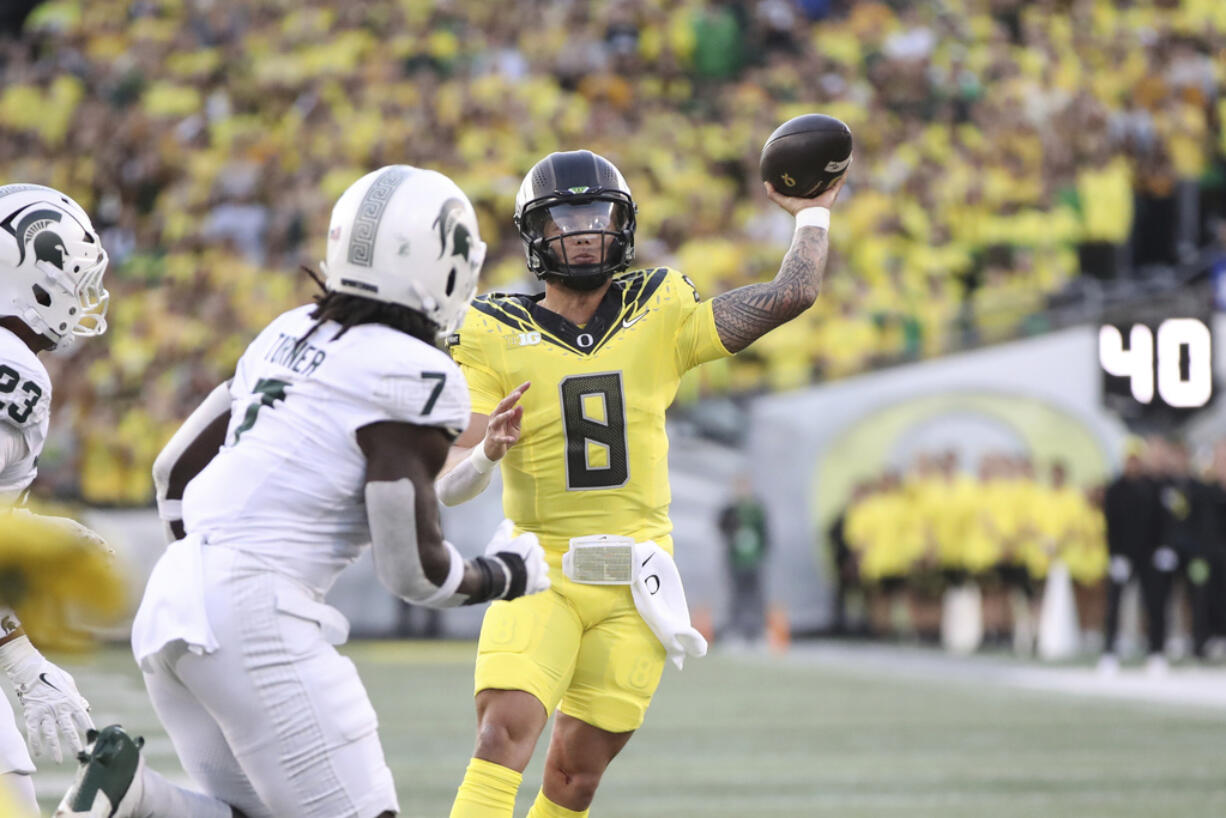 Oregon quarterback Dillon Gabriel (8) throws past Michigan State linebacker Jordan Turner (7) during the first half of an NCAA college football game, Friday, Oct. 4, 2024, in Eugene, Ore.