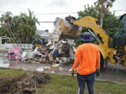 Salvage works remove debris from Hurricane Helene flooding along the Gulf of Mexico Monday, Oct. 7, 2024, in Clearwater Beach, Fla. Crews are working to remove the debris before Hurricane Milton approaches Florida's west coast.