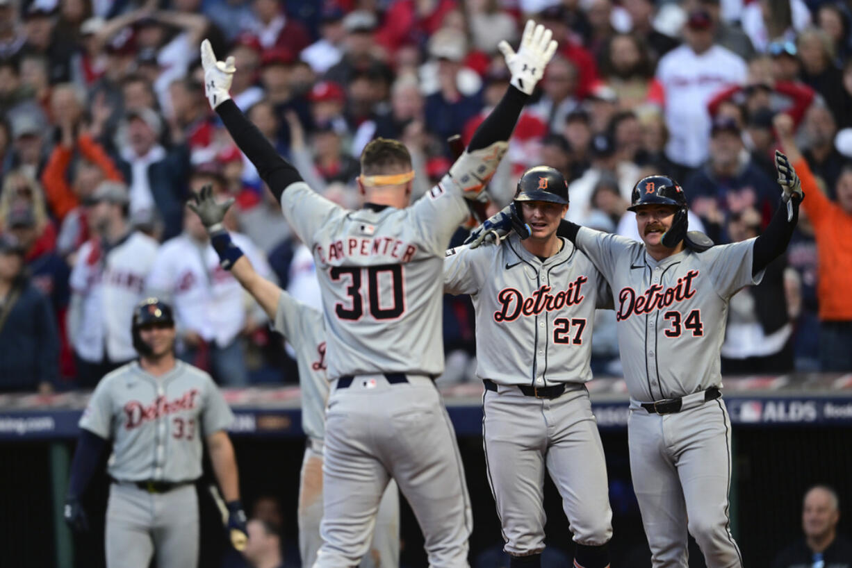 Detroit Tigers' Trey Sweeney (27) and Jake Rogers wait at home plate for teammate Kerry Carpenter after Carpenter hit a three-run home run in the ninth inning during Game 2 of baseball's AL Division Series against the Cleveland Guardians, Monday, Oct. 7, 2024, in Cleveland.