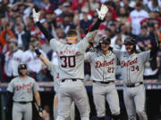 Detroit Tigers' Trey Sweeney (27) and Jake Rogers wait at home plate for teammate Kerry Carpenter after Carpenter hit a three-run home run in the ninth inning during Game 2 of baseball's AL Division Series against the Cleveland Guardians, Monday, Oct. 7, 2024, in Cleveland.