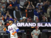 New York Mets' Francisco Lindor (12) rounds the bases after hitting a grand slam home run against the Philadelphia Phillies during the sixth inning of Game 4 of the National League baseball playoff series, Wednesday, Oct. 9, 2024, in New York.