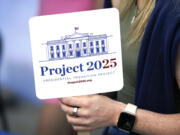 FILE - Kristen Eichamer holds a Project 2025 fan in the group's tent at the Iowa State Fair, Aug. 14, 2023, in Des Moines, Iowa.