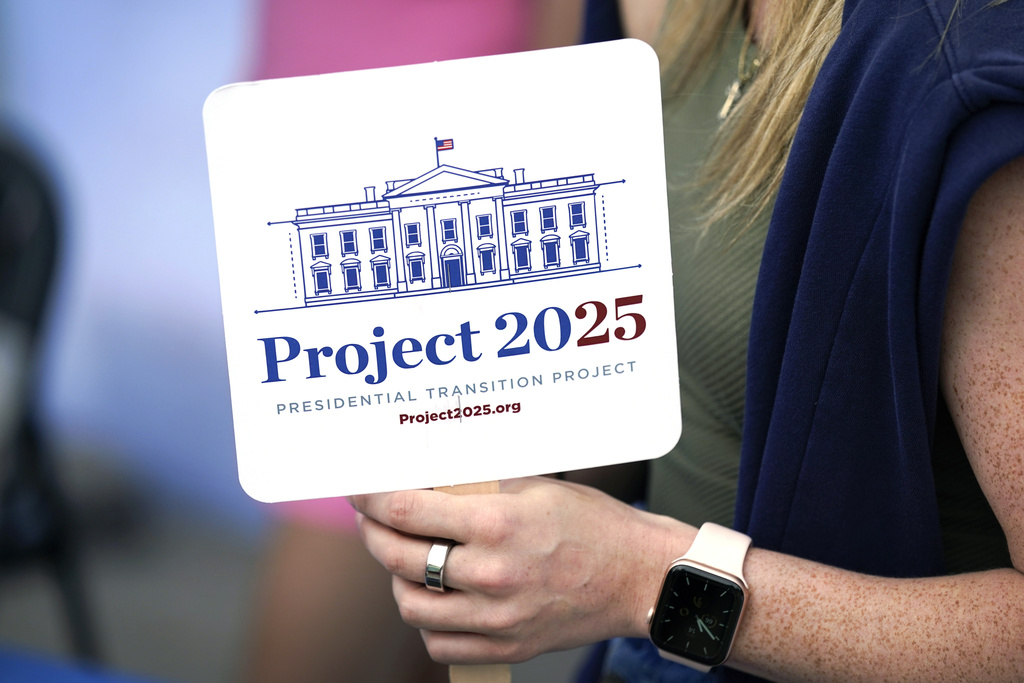 FILE - Kristen Eichamer holds a Project 2025 fan in the group's tent at the Iowa State Fair, Aug. 14, 2023, in Des Moines, Iowa.