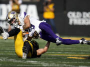 Washington wide receiver Audric Harris (13) is tackled by Iowa defensive back Zach Lutmer after catching a pass during the second half of an NCAA college football game, Saturday, Oct. 12, 2024, in Iowa City, Iowa. Iowa won 40-16.