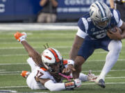 Nevada running back Savion Red (6) is grabbed Oregon State defensive back Skyler Thomas (17) in the first half of an NCAA college football game in Reno, Nev., Saturday, Oct. 12, 2024. (AP Photo/Tom R.