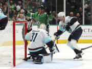 Dallas Stars center Sam Steel (18) reacts after scoring against Seattle Kraken goaltender Philipp Grubauer (31) and defenseman Will Borgen (3) in the first period during an NHL hockey game Sunday, Oct. 13, 2024, in Dallas. (AP Photo/Richard W.