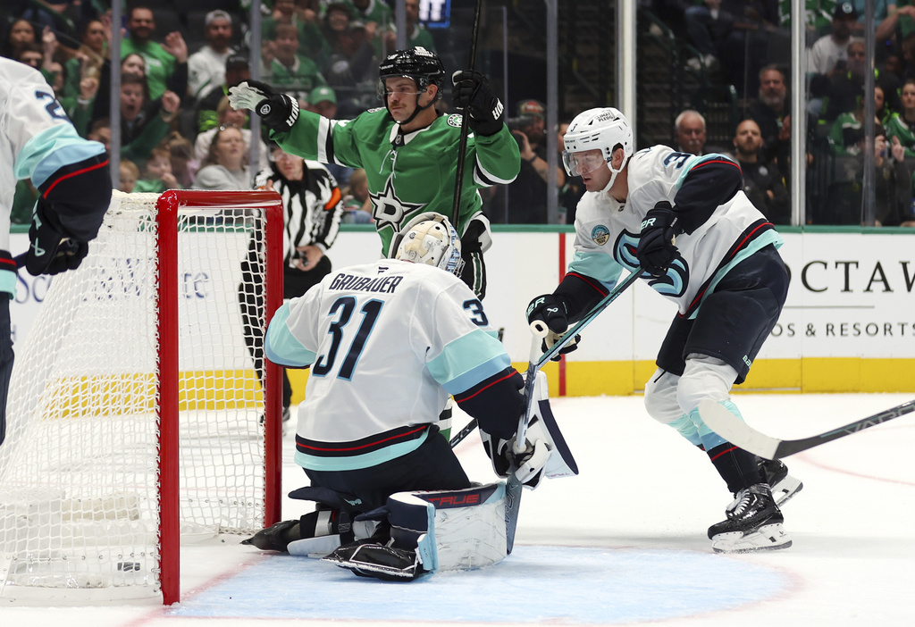 Dallas Stars center Sam Steel (18) reacts after scoring against Seattle Kraken goaltender Philipp Grubauer (31) and defenseman Will Borgen (3) in the first period during an NHL hockey game Sunday, Oct. 13, 2024, in Dallas. (AP Photo/Richard W.