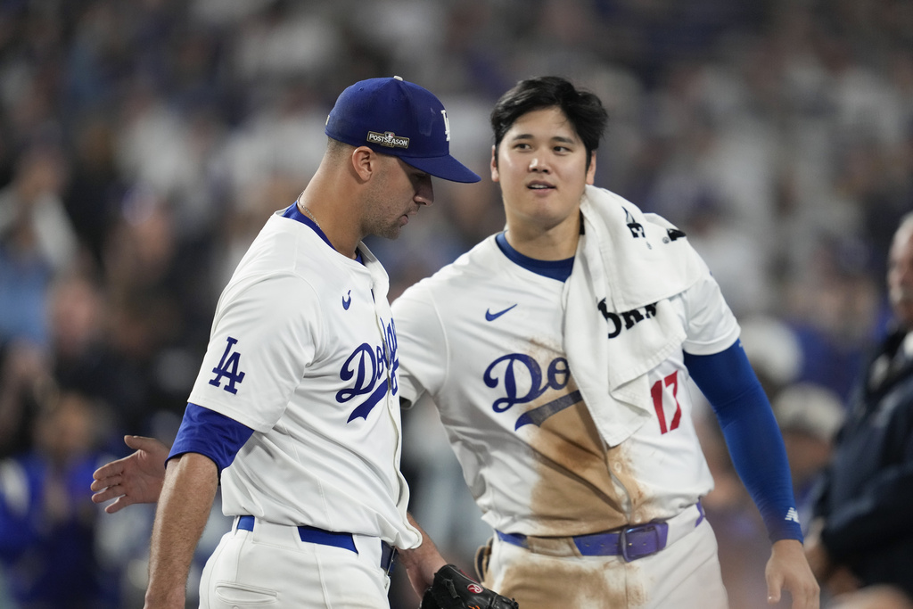 Los Angeles Dodgers pitcher Jack Flaherty, left, is greeted by Shohei Ohtani as he returns to the dugout during the seventh inning in Game 1 of a baseball NL Championship Series against the New York Mets, Sunday, Oct. 13, 2024, in Los Angeles.