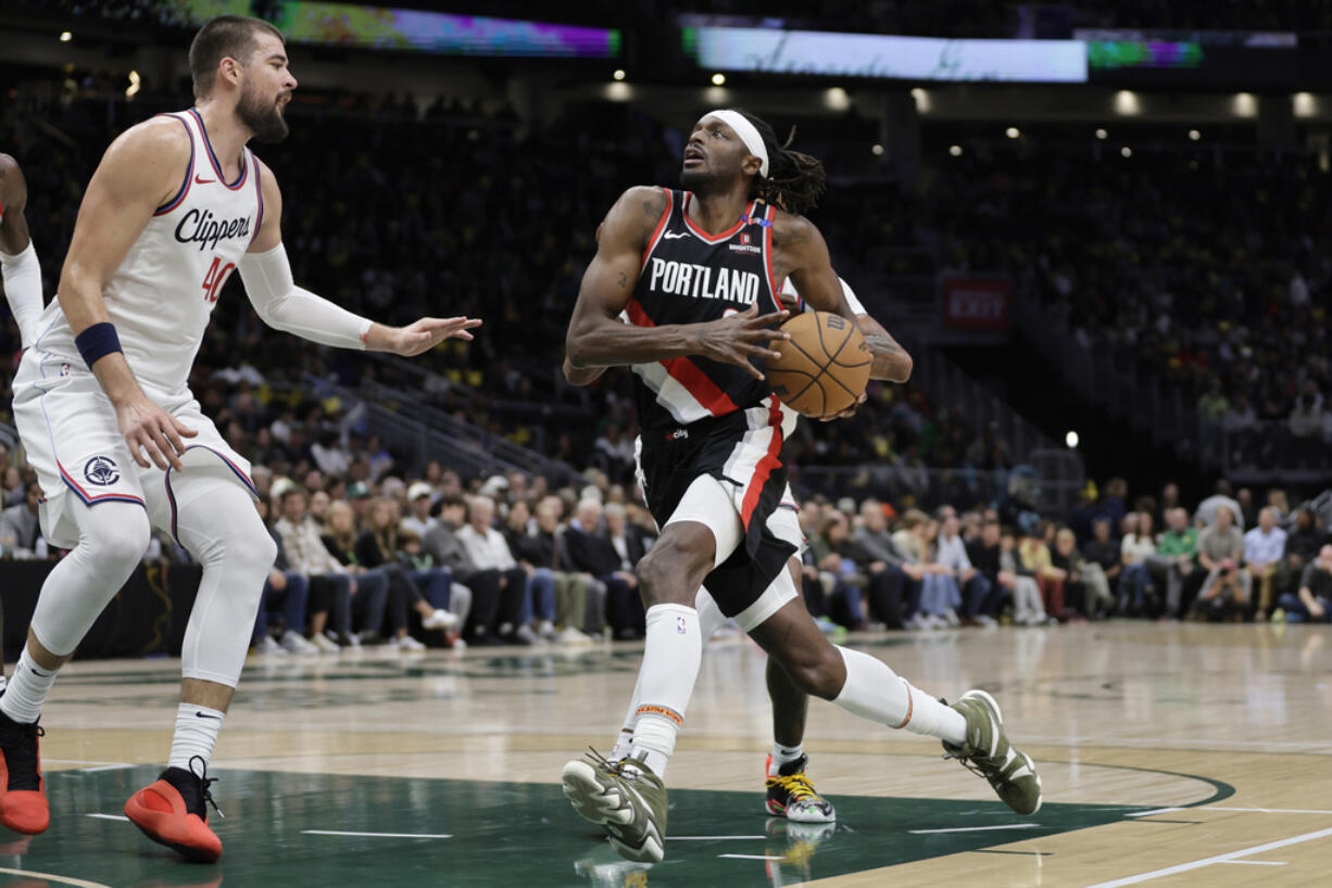 Portland Trail Blazers forward Jerami Grant (9) drives to the basket with Los Angeles Clippers center Ivica Zubac (40) defending during the first half of a preseason NBA basketball game, Friday, Oct. 11, 2024, in Seattle.