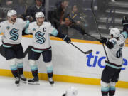 Seattle Kraken right wing Jordan Eberle, center, celebrates his goal with center Shane Wright (51) and defenseman Brandon Montour (62) during the third period of an NHL hockey game against the Nashville Predators, Tuesday, Oct. 15, 2024, in Nashville, Tenn.