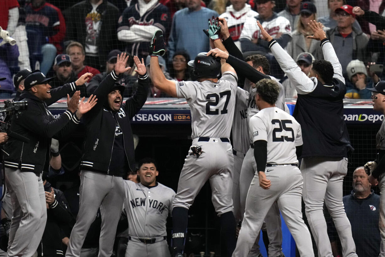 New York Yankees' Giancarlo Stanton (27) celebrates with teammates after hitting a home run against the Cleveland Guardians during the eighth inning in Game 3 of the baseball AL Championship Series Thursday, Oct.