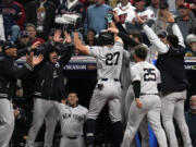 New York Yankees' Giancarlo Stanton (27) celebrates with teammates after hitting a home run against the Cleveland Guardians during the eighth inning in Game 3 of the baseball AL Championship Series Thursday, Oct.