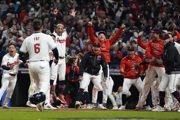 Cleveland Guardians players wait for David Fry (6) to cross home plate after hitting a game-winning two-run home run against the New York Yankees during the 10th inning in Game 3 of the baseball AL Championship Series Thursday, Oct. 17, 2024, in Cleveland. The Guardians won 7-5.