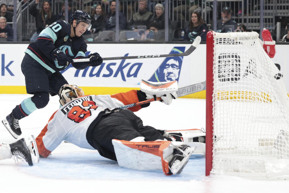 Seattle Kraken right wing Eeli Tolvanen (20) scores past diving Philadelphia Flyers goaltender Ivan Fedotov (82) during the second period of an NHL hockey game Thursday, Oct. 17, 2024, in Seattle.