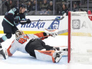 Seattle Kraken right wing Eeli Tolvanen (20) scores past diving Philadelphia Flyers goaltender Ivan Fedotov (82) during the second period of an NHL hockey game Thursday, Oct. 17, 2024, in Seattle.