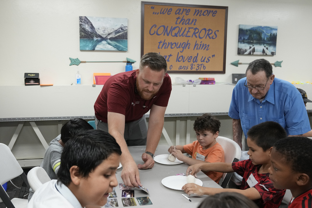 Trevor Cowling helps out during an activity class at a summer camp for youth at Valley Baptist Church Tuesday, June 18, 2024, in Mesa, Ariz. (AP Photo/Ross D.