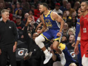 Golden State Warriors guard Stephen Curry (30) reacts after scoring a basket against the Portland Trail Blazers during the second half of an NBA basketball game Wednesday, Oct. 23, 2024, in Portland, Ore.