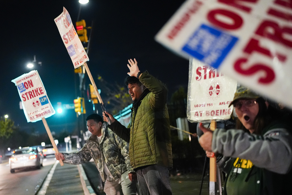 Boeing employees, including assembler Tyrone Hipolito, center, work the picket line after union members voted to reject a new contract offer from the company, Wednesday, Oct. 23, 2024, in Renton, Wash.