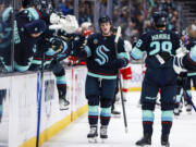 Seattle Kraken left wing Jared McCann, center, celebrates with teammates after his goal during the third period in an NHL hockey game against the Carolina Hurricanes, Saturday, Oct. 26, 2024, in Seattle.