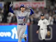 Los Angeles Dodgers' Freddie Freeman celebrates a two-run home run against the New York Yankees during the first inning in Game 3 of the baseball World Series, Monday, Oct. 28, 2024, in New York.