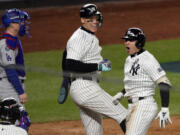 New York Yankees' Anthony Volpe, right, celebrates with Aaron Judge, center, after hitting a grand slam against the Los Angeles Dodgers during the third inning in Game 4 of the baseball World Series, Tuesday, Oct. 29, 2024, in New York.